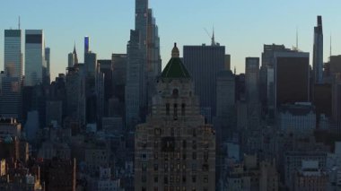 Gündoğumu New York şehrinin ufuk çizgisini sarar ve Midtown Manhattan gökdelenlerinin üzerine sıcak bir ışık saçar. Sabah ışığı şehir manzarasının güzelliğini ön plana çıkarıyor.