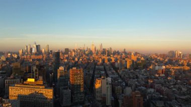 Sıcak güneş ışığı New York 'ta Manhattan şehir merkezinin manzarasını yıkıyor. Güneş batarken gökdelenler havadan bakıldığında uzun gölgeler bırakıyor..