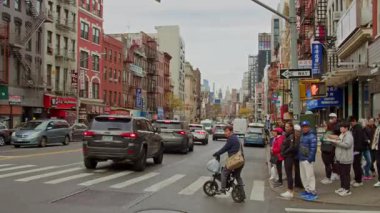 Turistler ve New York 'lular yaya geçidinde bekliyorlar ve sonra da Manhattan' ın Manhattan ilçesinde, Çin Mahallesi 'nde karşıdan karşıya geçiyorlar. NYC, ABD, 11.5.2024.