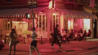 Manhattan 'da bir restoranın dışındaki canlı atmosfer. Misafirler açık masalarda oturup New York' ta sohbet ediyorlar. NYC, ABD, 11.5.2024.