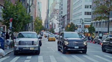 Araçlar, Manhattan, New York 'un güneyindeki ana cadde olan Yukarı Doğu Yakası' ndaki Madison Bulvarı boyunca ilerliyor. NYC, ABD, 11.5.2024.