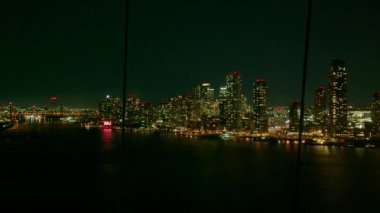 Long Island City gökyüzü geceleri parlıyor, Roosevelt Adası tramvay perspektifinden Doğu Nehri 'ni geçerken karanlık şehir manzarasını aydınlatıyor..