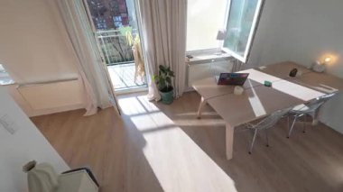 Günışığı altında modern minimalist yaşam alanının içinde yılan fabrikasıyla ilgilenen adam, modern ev dekoru tarzını vurguluyor, Berlin, 5.8.2025.