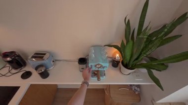 Modern mutfakta özel kahve imalatı, gösterişli aletler, güneşli çalışma alanı, tarafsız ortamda yeşil bitkilerle minimalist tasarım, Berlin, 5.8.2025.