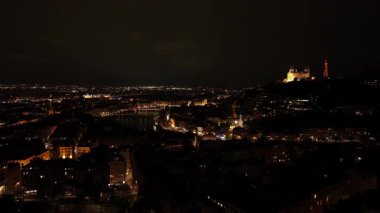 Gece hava manzarası Lyons 'un aydınlık şehir manzarasını gözler önüne seriyor. Fourviere bazilikası karanlık şehir manzarasına karşı parıldıyor. Pahalı gökyüzü..