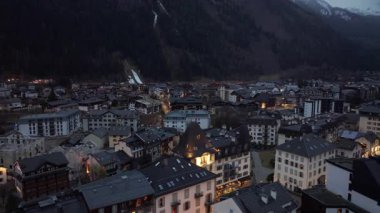 Fransız Alpleri 'nin alacakaranlık ışıkları sırasında dağlık Alp arazisinde parlayan Chamonix' i gösteren hava manzarası..