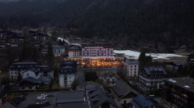 Yumuşak akşam parıltısı Chamonix vadisinde sıcak bir ışık yayıyor. Kış boyunca engebeli Fransız dağlık arazisindeki alp dinginliğini vurguluyor..