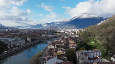 Gökyüzü manzarası Grenobles 'un tarihi merkezini, Alpler' in altından akan Isere nehrini, görkemli dağ sıraları tarafından çerçevelenmiş..