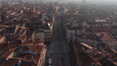Toulouse şehir manzarası kırmızı tuğlalı binalar, tarihi sokaklar, yüksek açılı çatılar parlak güneş ışığı altında, mimari mirası yakalıyor..