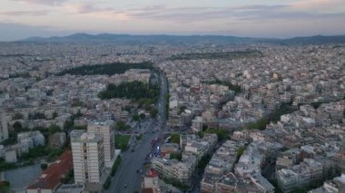 Yunanistan 'ın Selanik kentinde arabalar hareketli caddelerde dolaşırken hava görüntüleri görülüyor. Şehir gün batımının sıcacık parıltısı altında ışıldıyor, canlı şehir manzarasını vurguluyor..