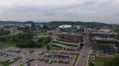 Litvanya 'nın Vilnius şehrinde çatıda basketbol sahası olan Forum Palace adlı modern bir binanın etrafında dönen hava manzarası. Aşağıdaki caddelerde arabalar sürüyor..