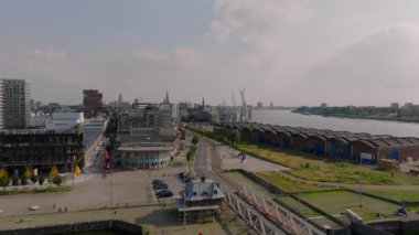 Belçika 'nın Antwerp kentindeki Scheldt Nehri' nin kıyısında binalar ve sokaklar bulunmaktadır. Arabalar ve yayalar güneşli bir günde seyahat ediyorlar..