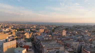 Altın saat boyunca Yunanistan 'ın Selanik kentinin çatılarında kameralar görülüyor. Termaik körfez ve liman uzaklıktan görülebiliyor..