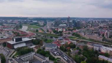 Vilnius şehir merkezinde, şehrin çeşitli tasarım mirasını yansıtan modern ve tarihi mimarinin bir karışımını sergileyen Neris Nehri soldan sağa akıyor..