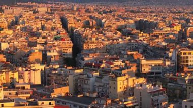 Günbatımının ılık renkleri Yunanistan 'ın Selanik kentinin sokaklarını ve binalarını sarıyor. Olimpos Dağı uzaktan görülebilir..