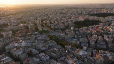 Gündoğumunda Yunanistan 'ın Selanik kentinin hava manzarası. Binalar ve sokaklar, alacakaranlık güneşinin altın ışığıyla yıkanır..