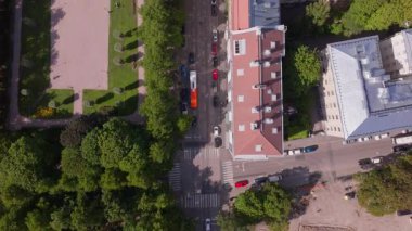 Helsinki, Finlandiya 'da bir sokak ve park üzerinde ilerleyen hava manzarası. Arabalar sürüyor ve insanlar kaldırımda yürüyor..