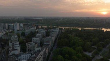 Günbatımının sıcacık parıltısı Vistula Nehri 'ni ve Polonya' nın Varşova kentsel manzarasını yıkar ve güzel bir hava manzarası yaratır..