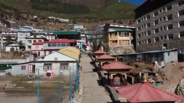 Dağlarda yuva yapmış tuhaf bir Nepal köyünün havadan görünüşü, sabahın erken saatlerinde gökyüzünün altında geleneksel mimari ve dua tekerleklerini gösteriyor..