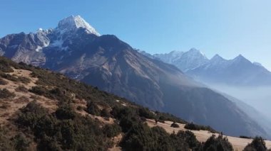 Nepal 'deki uzak dağ patikalarının havadan görünüşü, görkemli kar örtülü zirvelerin zeminine karşı yürüyüş yapanları gösteriyor..