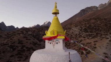 Nepal dağlarına kurulmuş uzak bir köyün havadan görünüşü, geleneksel mimariyi gözler önüne seriyor ve arka planda muhteşem bir kar tepesi var..