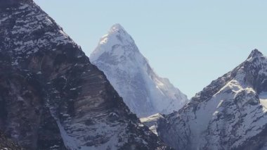 Nepal 'in Himalayaları' nda sabah erken saatlerde açık gökyüzü ile yakalanan karla kaplı bir dağın nefes kesici manzarası..