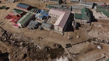 Kültürel binalar ve görkemli karlı zirvelerin yer aldığı izole bir Nepalli yerleşim bölgesinin yukarıdan çekimleri.