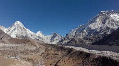 Himalayalar 'daki gözlerden uzak bir Nepal köyünün insansız hava aracı çekimi. Geleneksel taş mimarisi ve yükselen karlı bir zirve..
