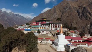 Nepal dağlarına kurulmuş sakin bir köyün havadan görünüşü. Geleneksel mimarileri ve arka planda görkemli karla kaplı bir tepe..
