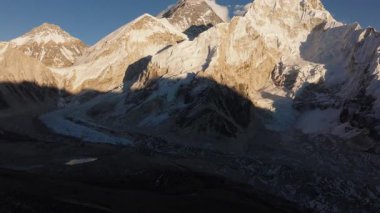 Nepal 'in Himalayaları' ndaki karlı dağların hava manzarası şafak vakti bir buzul vadisinin dingin güzelliğini yakalıyor..