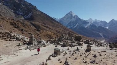 Ama Dablam ve geleneksel dua bayraklarının yer aldığı Nepal 'deki uzak bir dağ vadisinin havadan görünüşü.