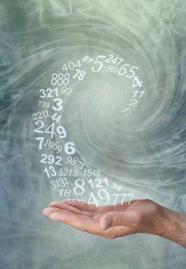 Numerolojist, sayıların akışı üzerinde çalışıyor. Avuç içinden yükselen rastgele sayılar sarmalı ile erkek eli, bilge yeşil dönen enerji alanı arka planına karşı.