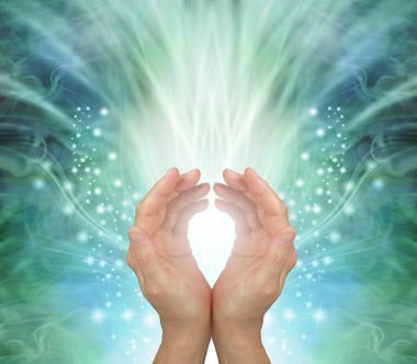 Channeling heart chakra healing energy to you - female cupped hands against a stunning radiating ethereal green energy field background with copy space for messages