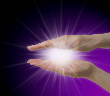 Sending Purple Ray Healing Energy - female parallel hands with a beautiful white star burst orb between against a purple graduated to black background and copy space