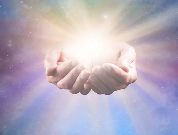 stock image Connect with Divine Intelligence and All That Is - mature male healers cupped hands with bright healing star light radiating outwards against celestial background ideal for a spiritual holistic healing theme
