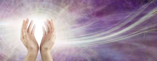 Sending beautiful healing intention across the ether - female open cupped hands with a white orb and trail of light against ethereal magenta pink background with copy space
