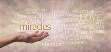 Soluk renkli arka planda MIRACLES ile ilişkilendirilen sözcükler - Kadın açık avuç içi MIRACLES yukarıda süzülüyor cilt renkli arka planda ikinci olay sözcükleri ile çevrili
