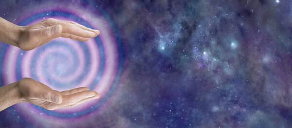Reiki Master Healer sensing awesome vortexing energy - male cupped hands and spiralling pink energy formation against deep space dark night sky background and copy space for message