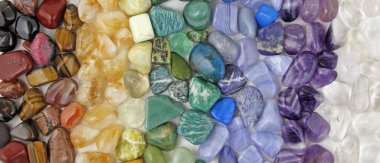 Çakra Kristali Şifa Geniş Arkaplan Şablonu - Cilalanmış sıralar halinde chakra renklerinde serili şifa kristali beyaz, mor, mavi, yeşil, sarı, turuncu, kırmızı kristal iyileştirme teması için ideal