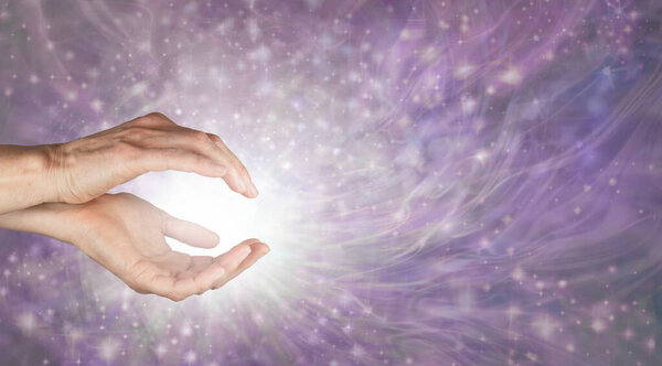 Приходите и наслаждайтесь целебной энергией рейки - женские руки с белым светом и красивым сияющим фиолетовым энергетическим полем из искр с копировальным пространством для духовного послания