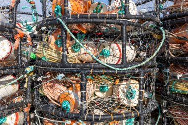 Halatlar, şamandıralar ve diğer balıkçı malzemeleriyle dolu istiflenmiş yengeç kaplarının detaylı görüntüsü.. 