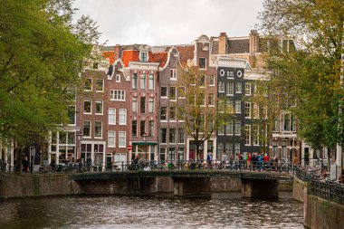 Amsterdam, Hollanda: 13 Ekim 2017: Amsterdam 'ın köprülü küçük kanalları. Bisikletçiler, turistler ve yerel halkla dolu..
