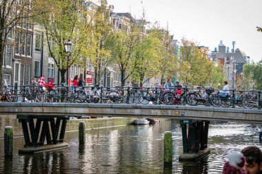 Amsterdam, Hollanda: 13 Ekim 2017: Amsterdam 'ın köprülü küçük kanalları. Bisikletçiler, turistler ve yerel halkla dolu..