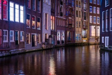 Hollanda, Amsterdam 'da uzun bir kanal görüntüsü var. Gece boyunca güzel ve renkli ışıklar.