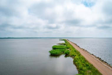 Güneşli bir yaz günü Letonya 'nın Liepaja kentindeki Liepaja Gölü' ne doğru iskeledeki At Adası Kuş Gözetleme Kulesi