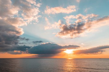 Colofrul sunset at the Baltic sea coastiline in Liepaja, Latvia. Sun coming out of the clouds with beautiful evening color in golden hour clipart