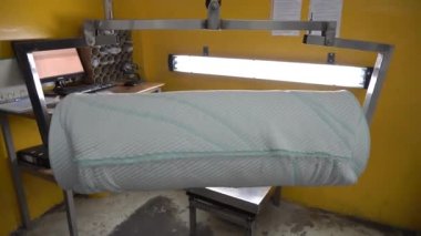 Asansör bir rulo kumaşı kaldırıyor. Tekstil endüstrisi