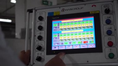 İşçi, tablet bilgisayarlı bir Cnc makinesi programlıyor. Tekstil Fabrikası