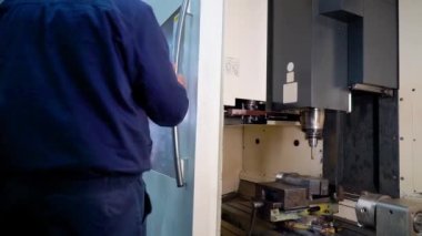 İşçi, Cnc makinesinin kapısını kapat. Yakın çekim.