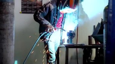 İşçi yarı otomatik kaynak makinesiyle çelik parçaları kaynaklıyor.